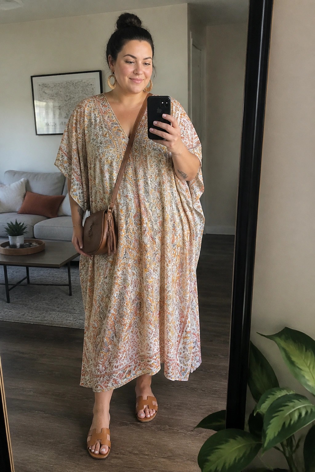 Woman in beige floral maxi dress taking mirror selfie with brown purse
