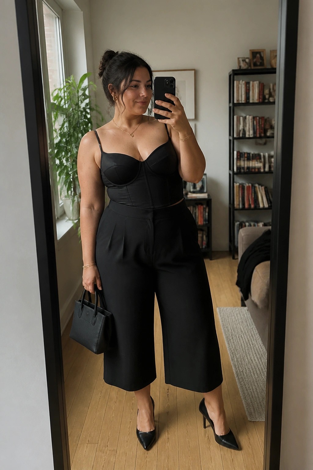 Woman in black corset top and wide cropped pants taking mirror selfie