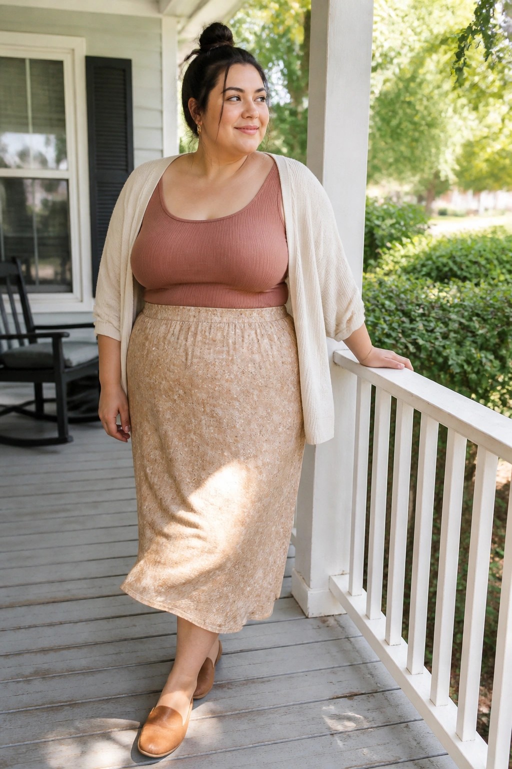 Woman in rose tank top and beige patterned skirt on porch railing