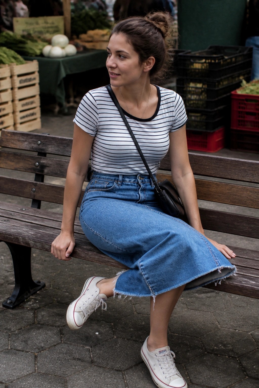 Woman in striped shirt and frayed denim skirt on wooden market bench
