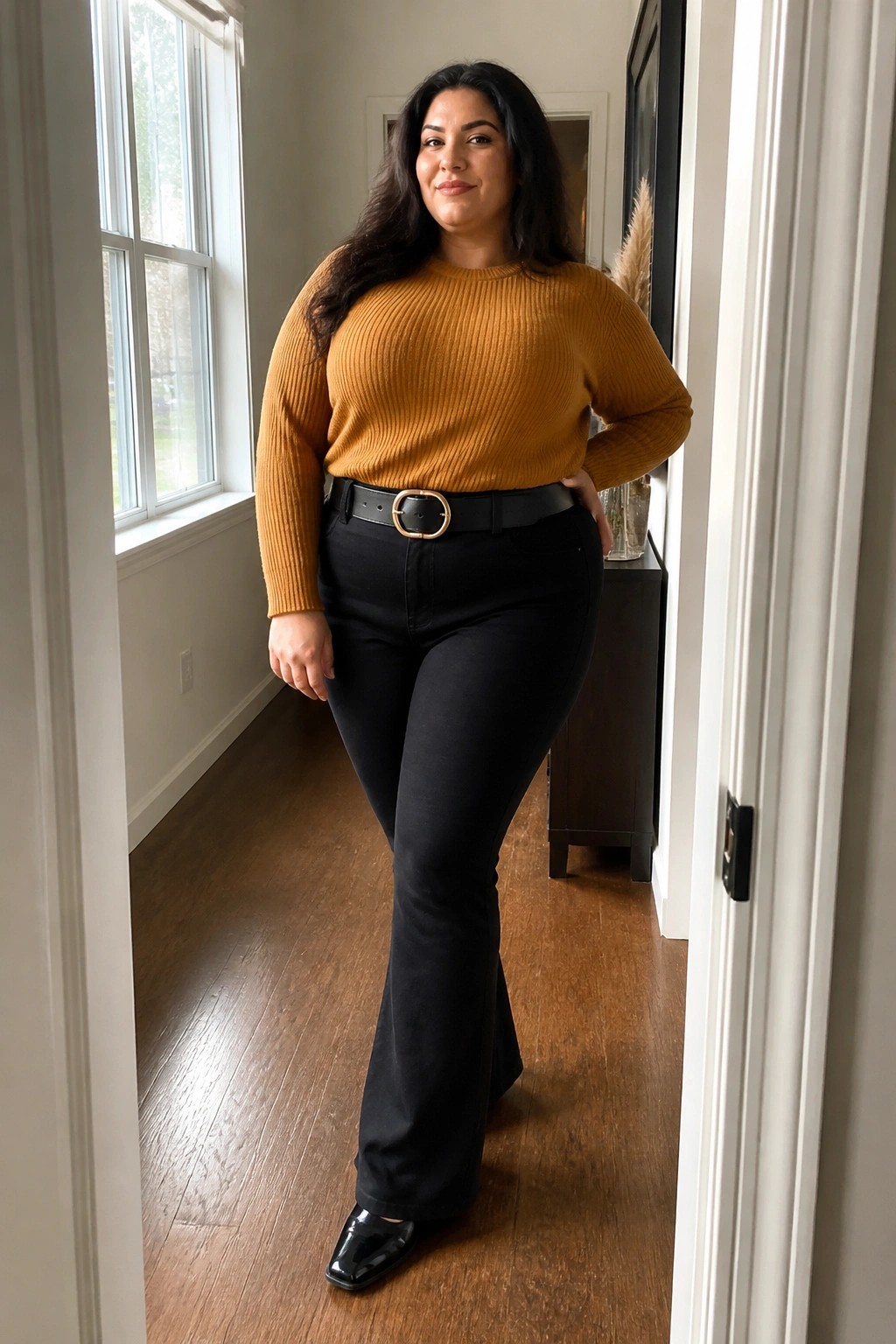 Woman in mustard ribbed sweater and black flared pants posing indoors