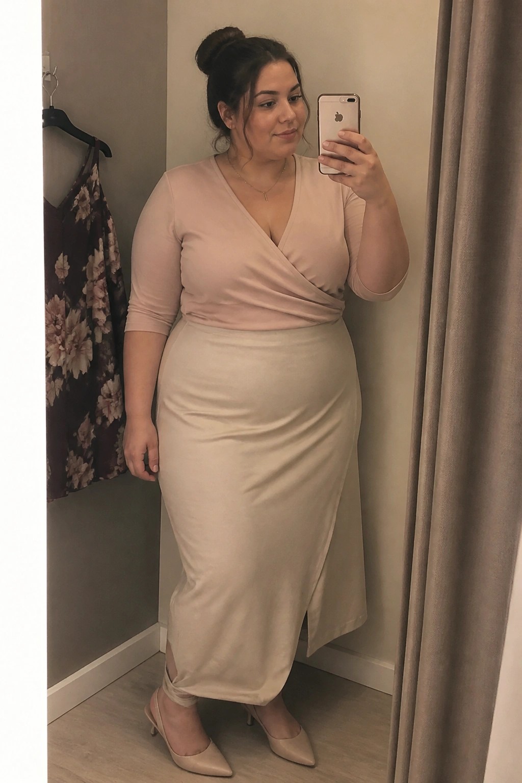 Plus-size woman in beige wrap top and midi skirt taking mirror selfie