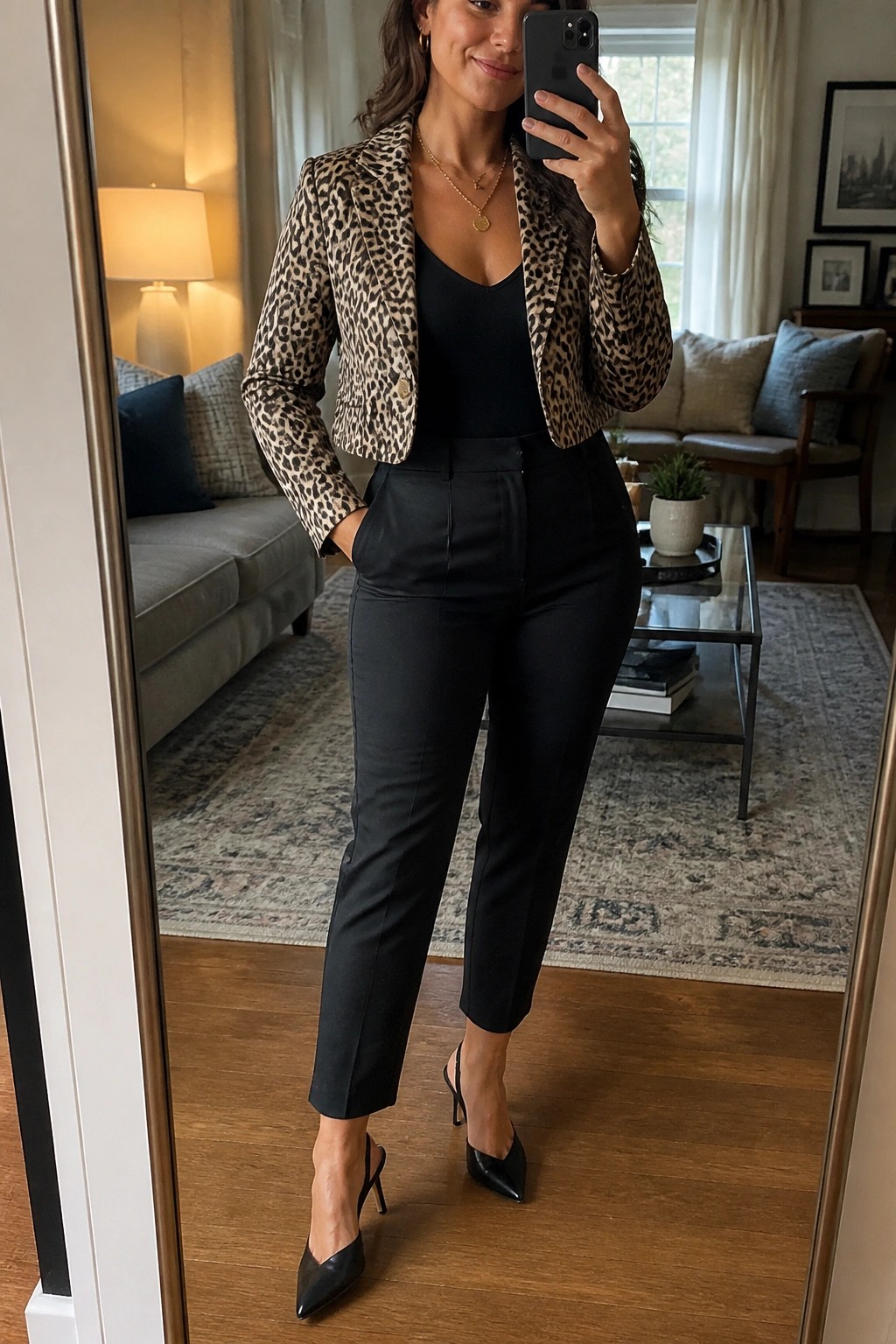 Woman wearing a cropped leopard print blazer over a black v-neck top with high-waisted black trousers and black pointed slingback heels, posing in a mirror selfie.