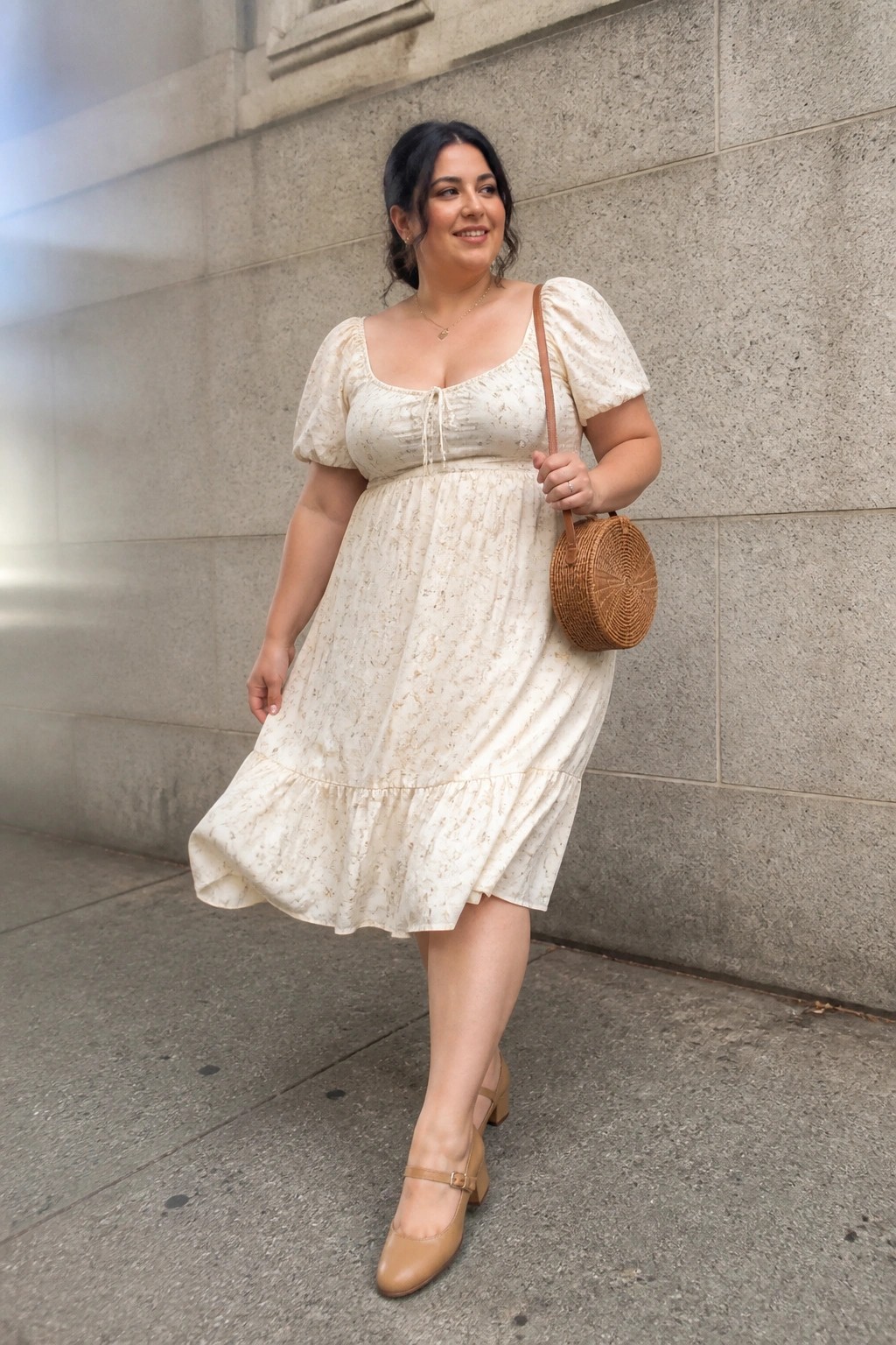 Plus size woman wearing a cream floral print midi dress with puff sleeves square neckline and front tie detail paired with beige Mary Jane block heels and a round woven crossbody bag.