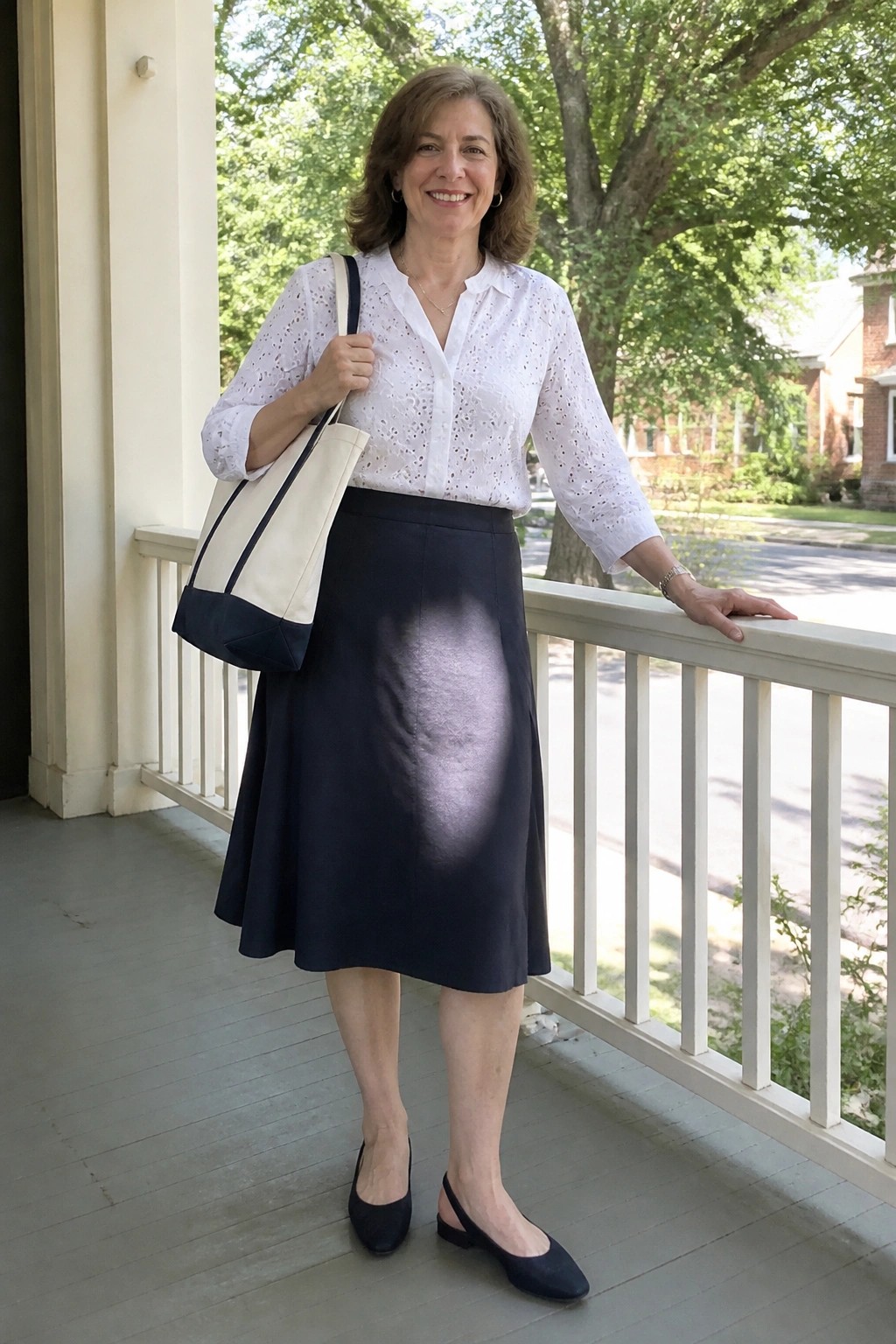 Woman in white eyelet blouse and stained navy skirt holding tote on porch