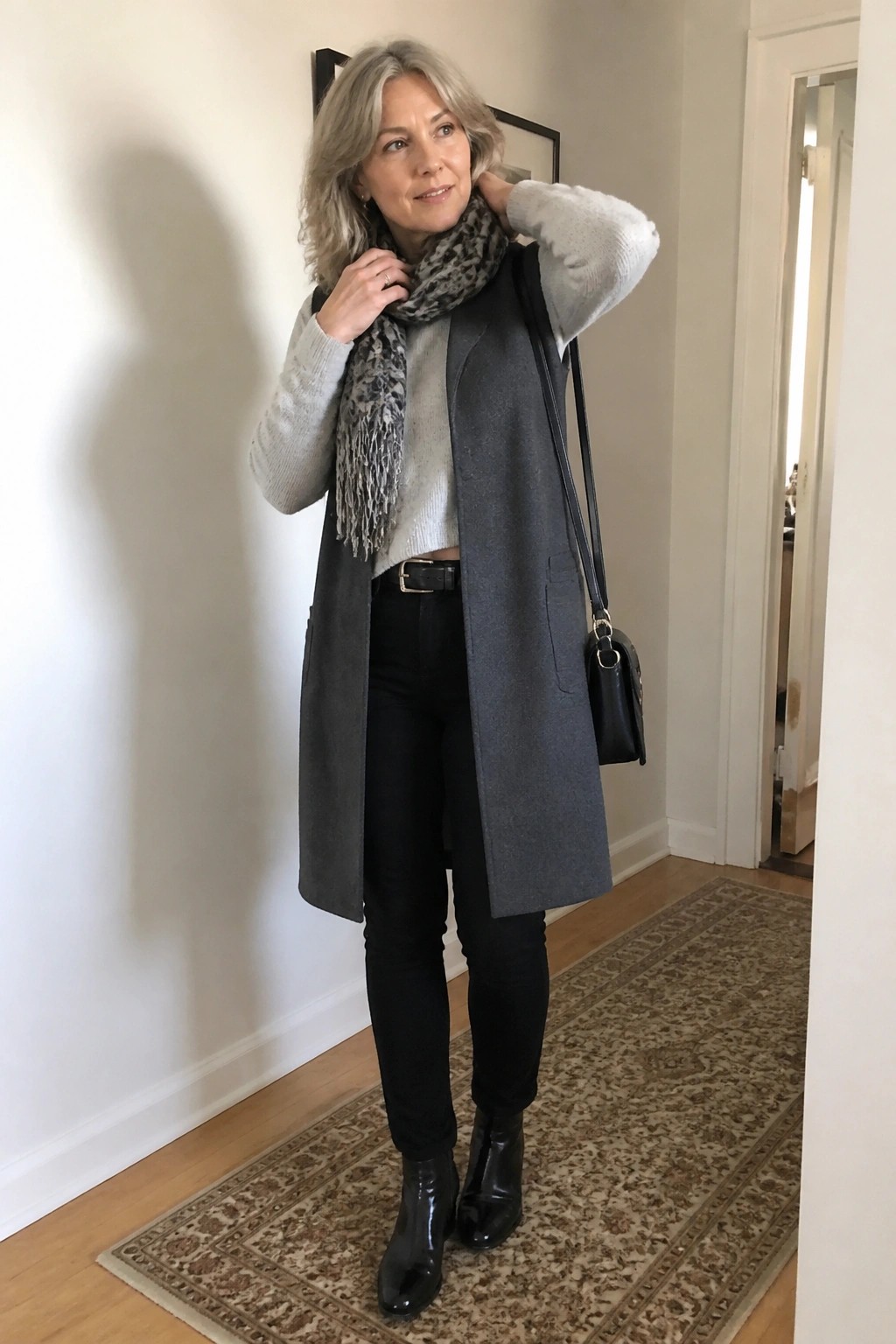 Silver-haired woman in gray vest and leopard scarf with black boots indoors